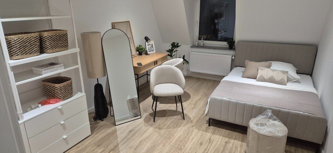 Fertig montiertes Schlafzimmer mit Schwebetürenschrank und verlegtem Laminatboden